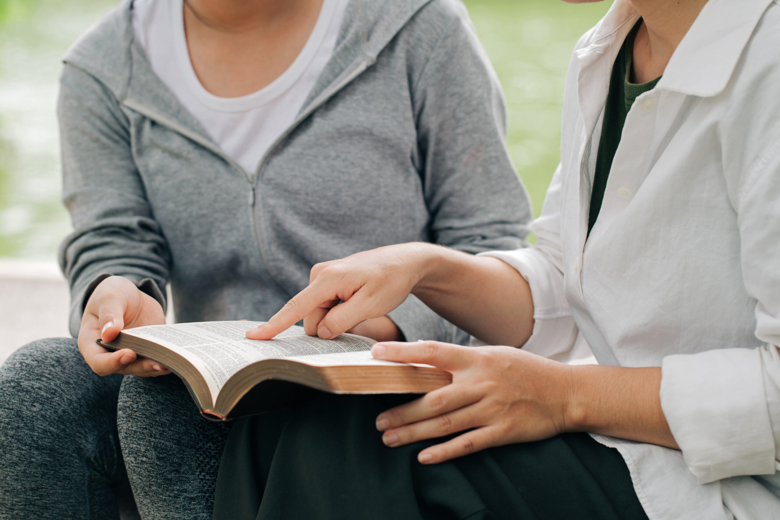 Two women studying and talking about the bible .